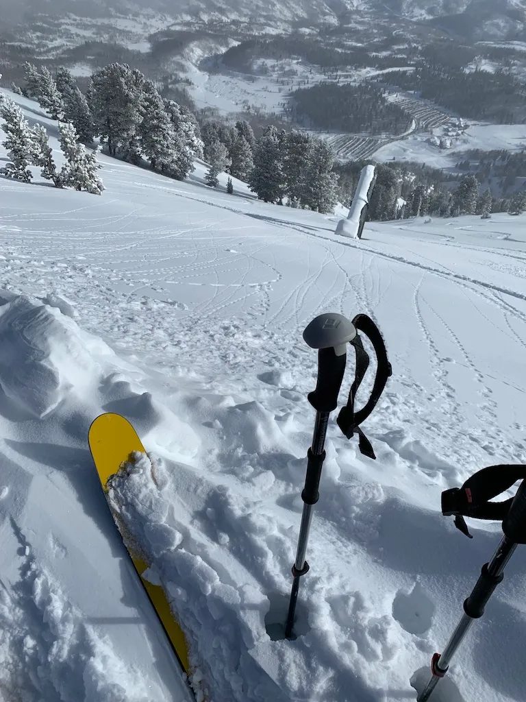 Ski tip and poles in deep powder on a run at Snowbasin