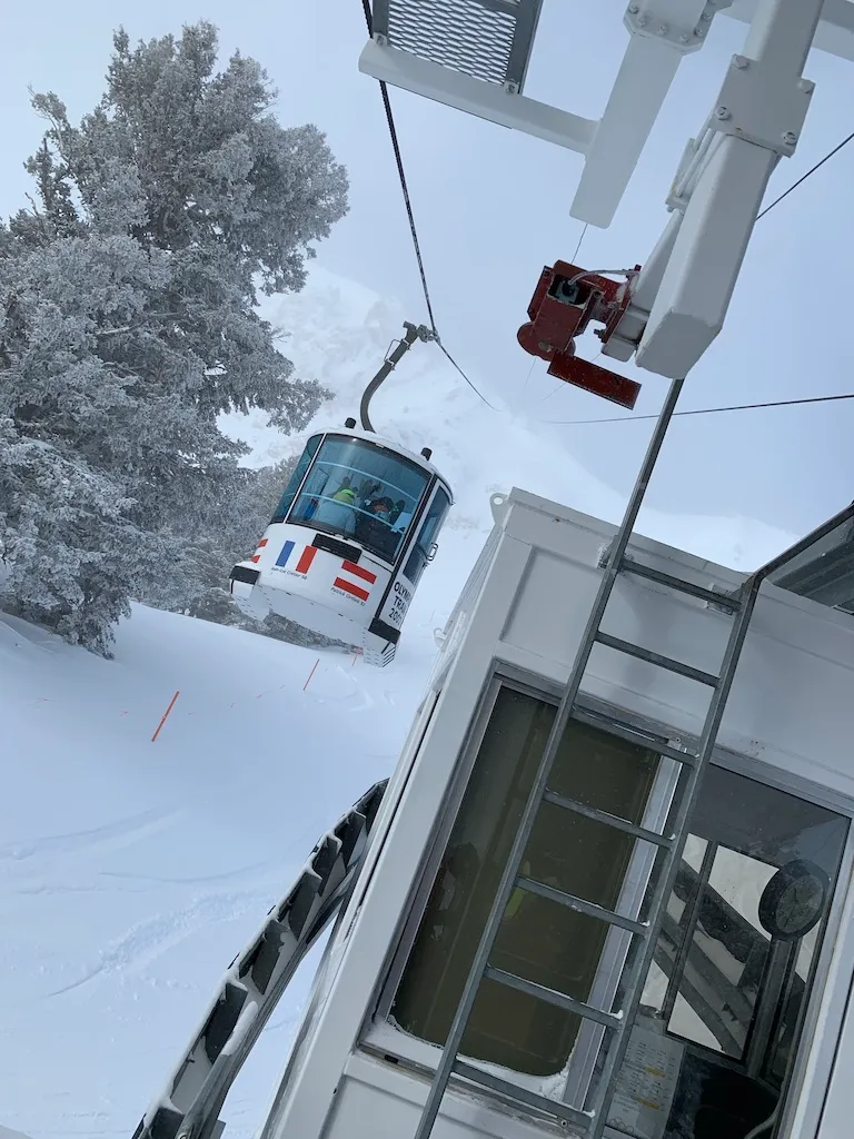 Gondola cabin on its cable above a lift terminal building